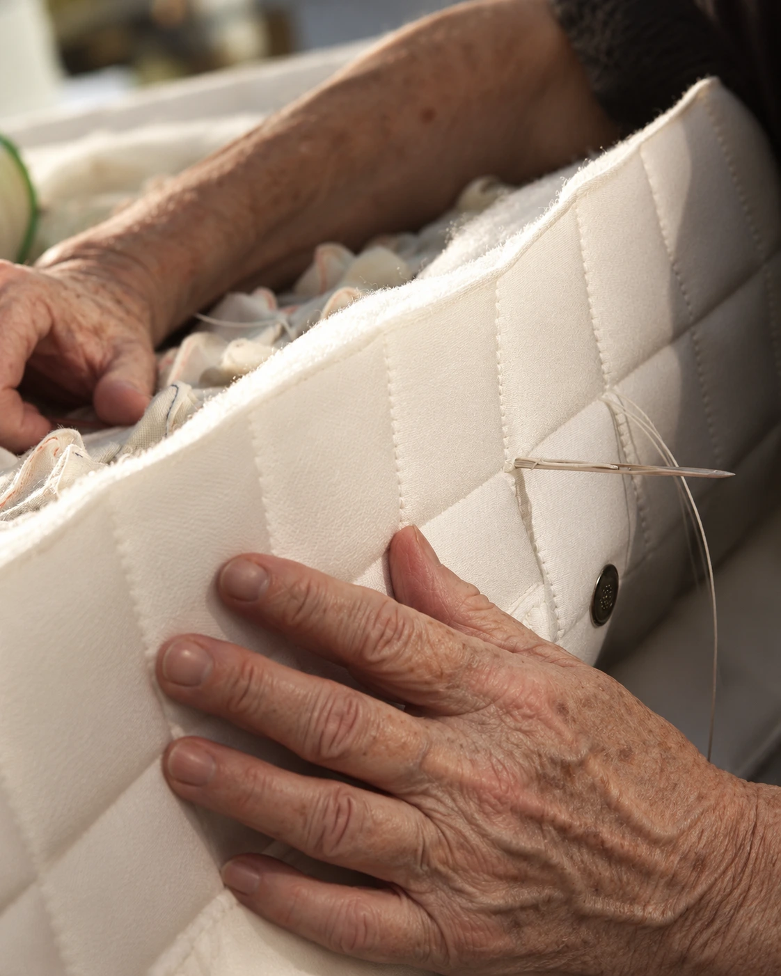 Artisan hand-finishing a natural wool mattress